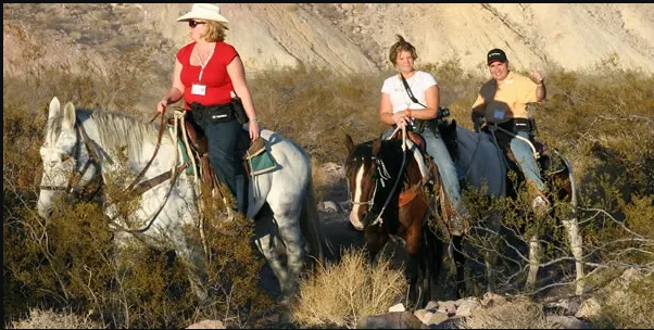 Four riders at red rock formations near Las Vegas
