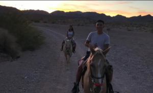 Three riders on dusty trail near Henderson NV
